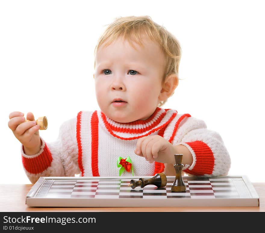 A kid plays a chess with a serious face