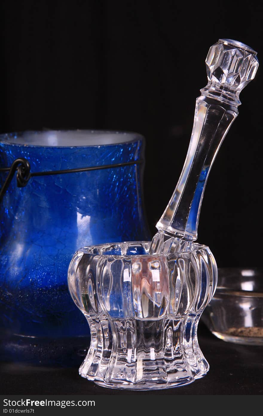 Blue cauldron with smoke coming out of it in the background of a crystal mortar and pestle