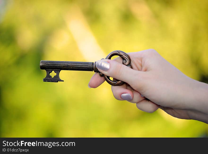 Key in a hand on bright background. Key in a hand on bright background