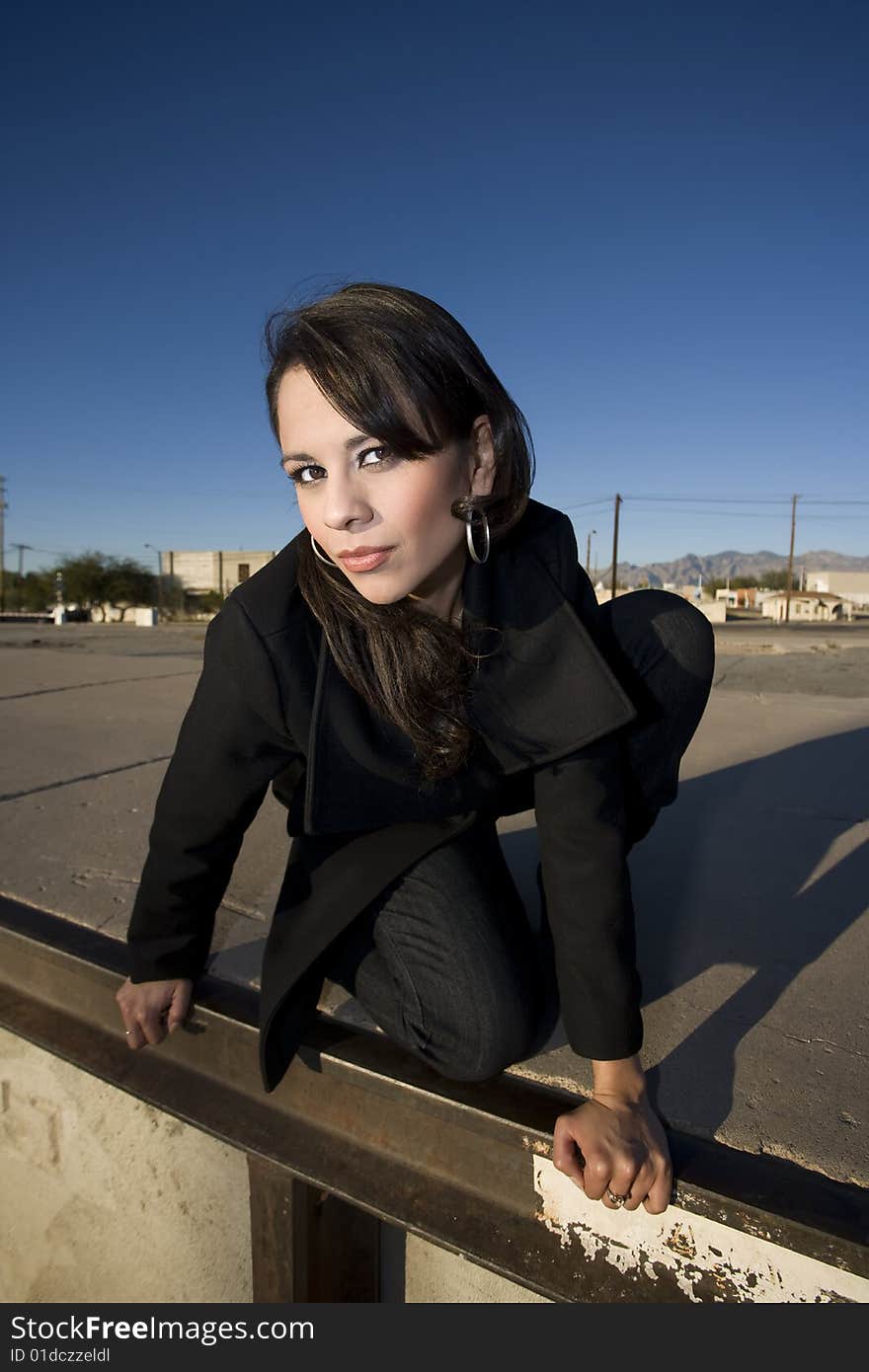 Beautiful woman in black trenchcoat in an urban setting. Beautiful woman in black trenchcoat in an urban setting