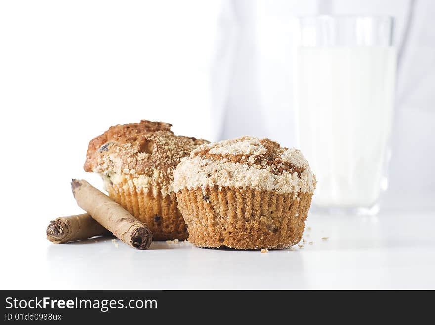 Two muffins on white background with glass of milk