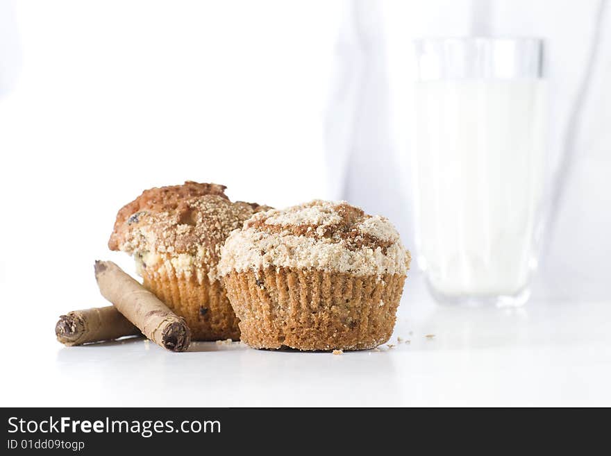 Two muffins on white background with glass of milk