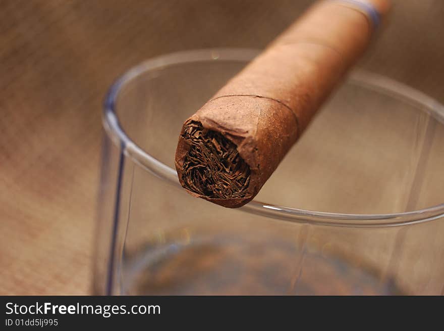 Cuban cigar on glass with whiskey