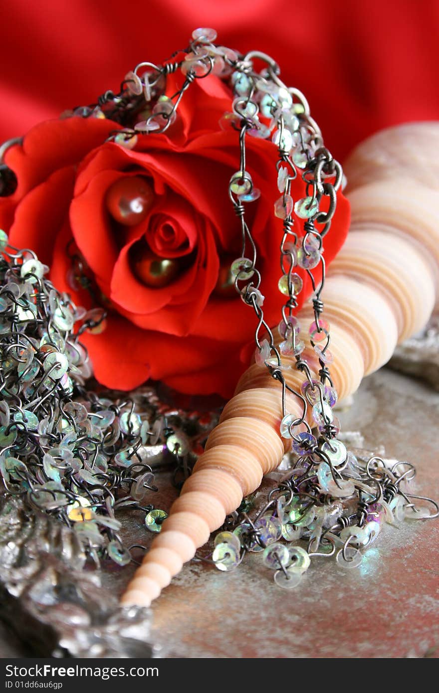 Red rose with fine jewelery on a seashell. Red rose with fine jewelery on a seashell