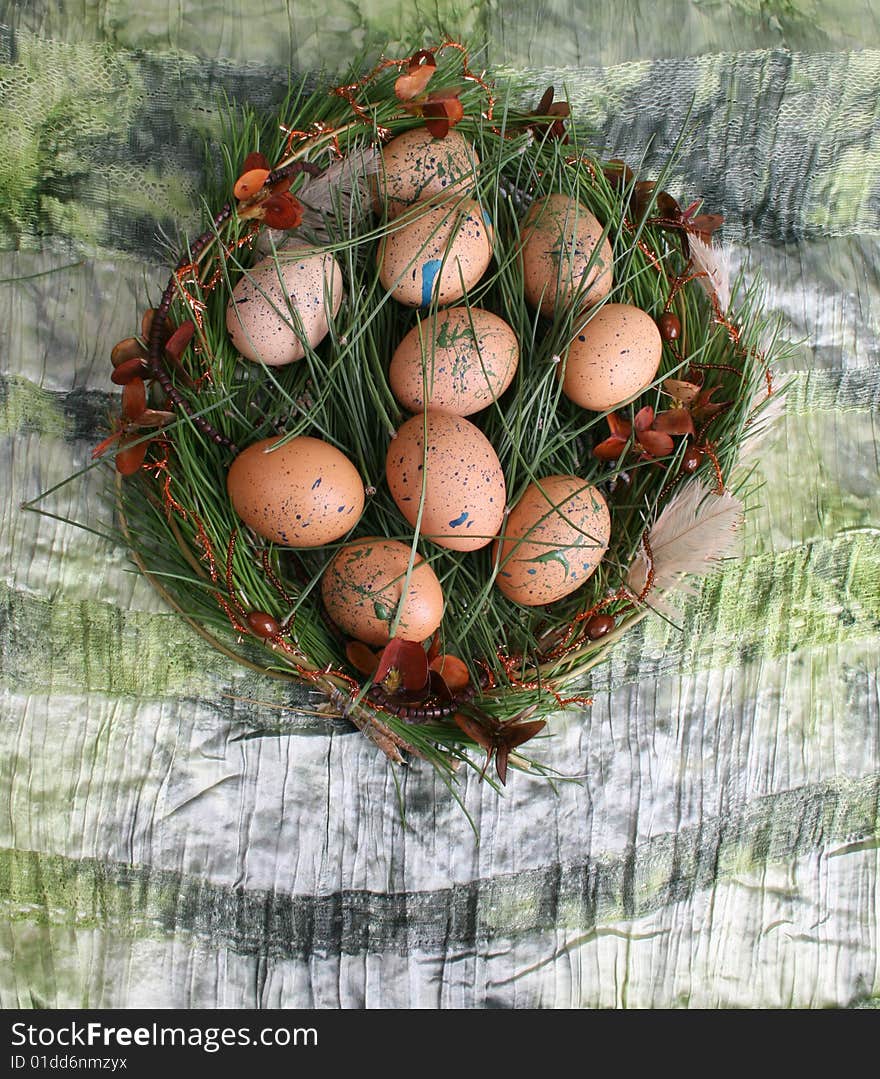 Decorated eggs in a wreath on a green background. Decorated eggs in a wreath on a green background