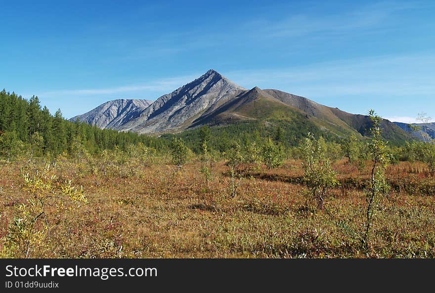 Photo. Mountain and hills against a backdrop of blue sky. Forest. Photo. Mountain and hills against a backdrop of blue sky. Forest.