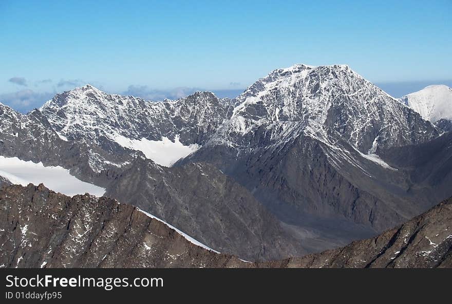 Photo. The mountains covered with snow. A blue sky.