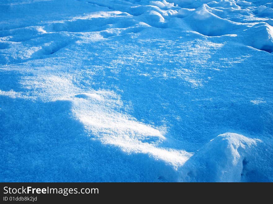 Tracks sprinkled snow. It is taken picture in a sun day - pls are deep dark blue, snow sparkles.