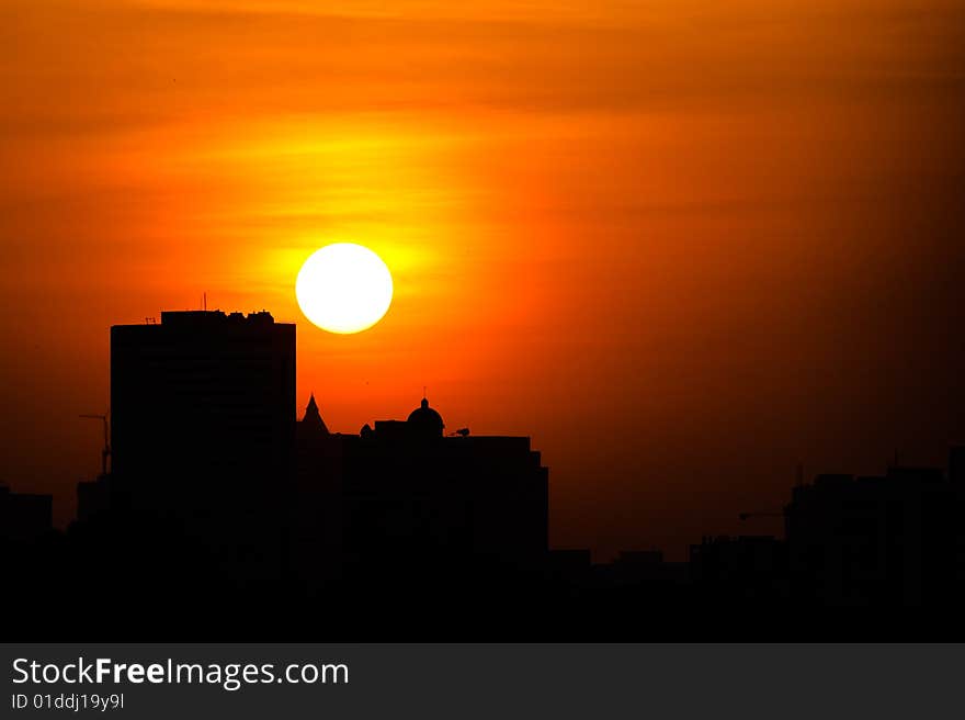 Picture of buildings with sun setting in the background. Picture of buildings with sun setting in the background.