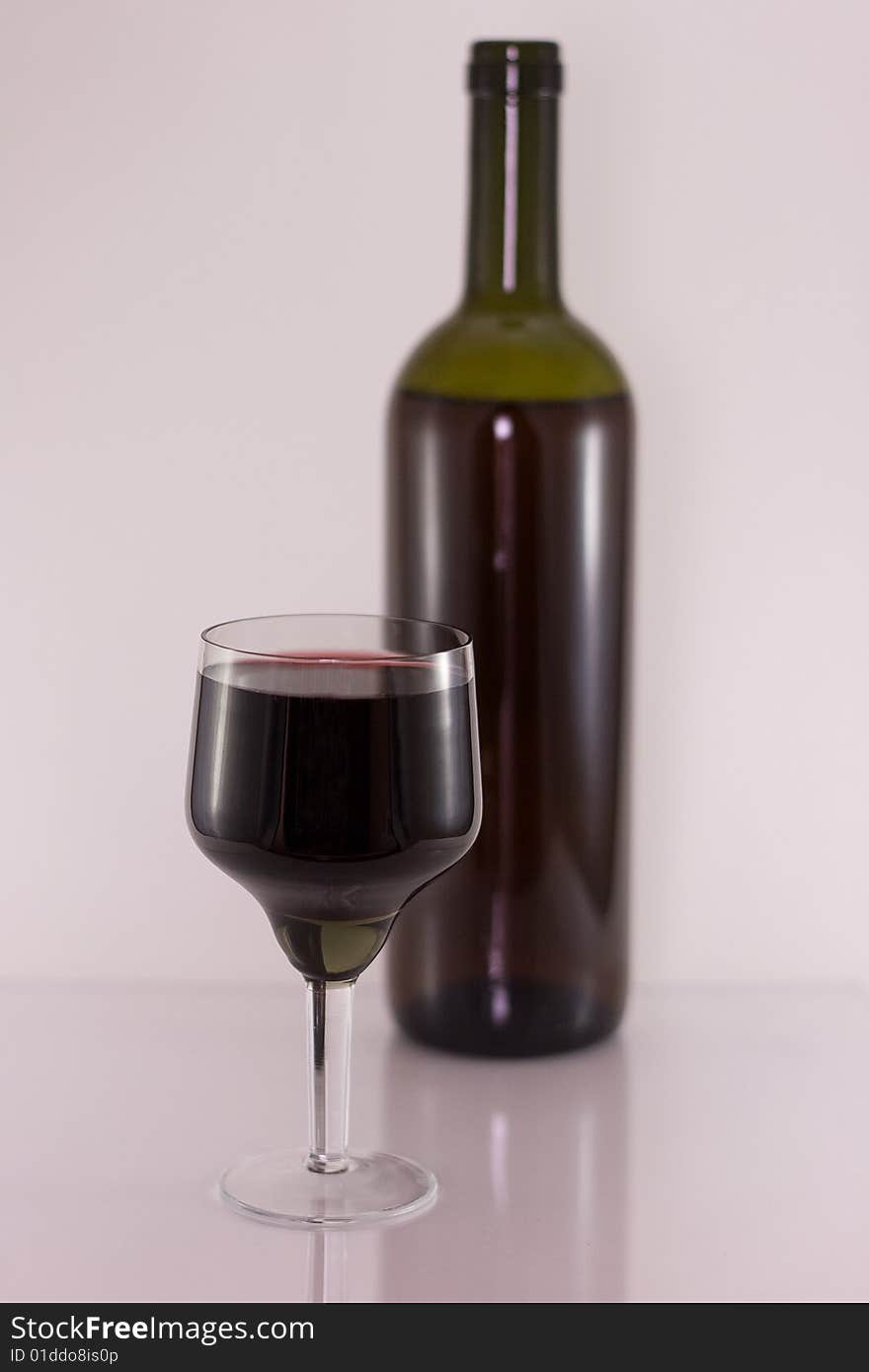 Glass and bottle with red wine