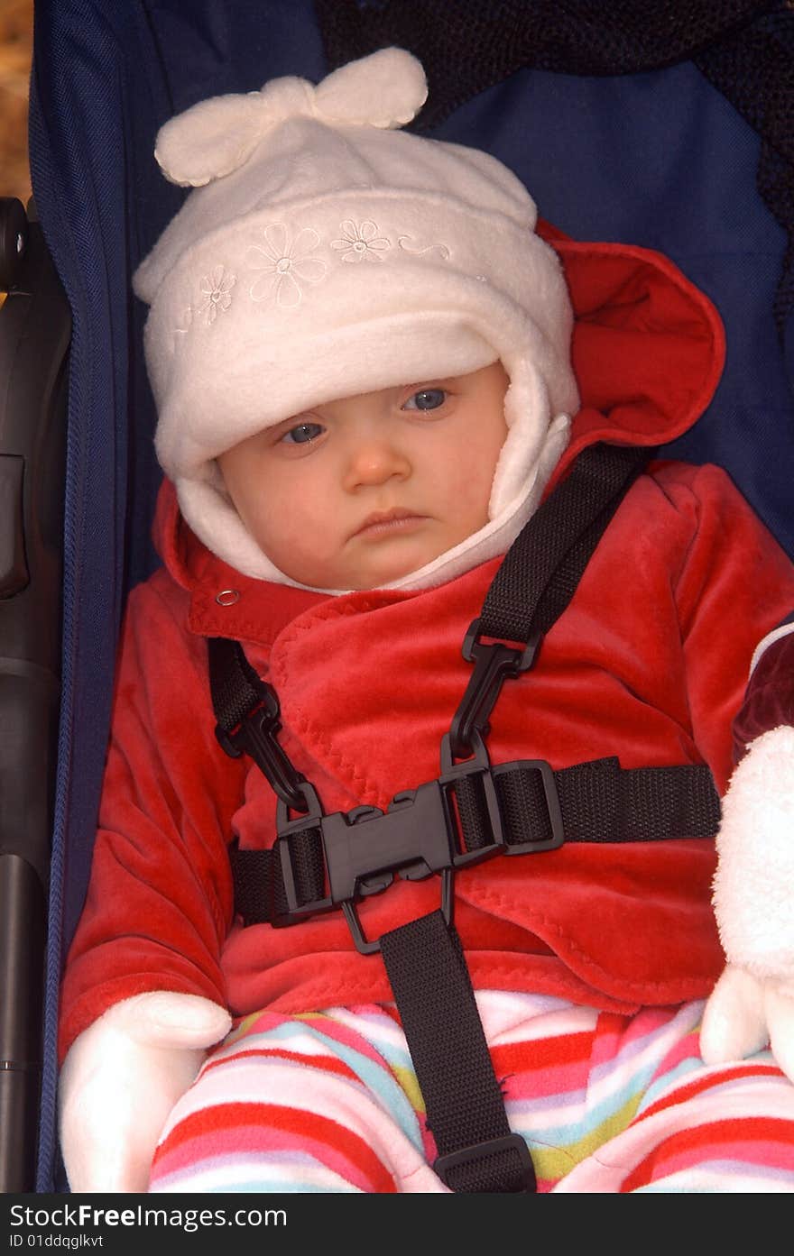 With a look of total boredom in her eyes, an infant girl sits in her stroller patiently waiting to get going. With a look of total boredom in her eyes, an infant girl sits in her stroller patiently waiting to get going.