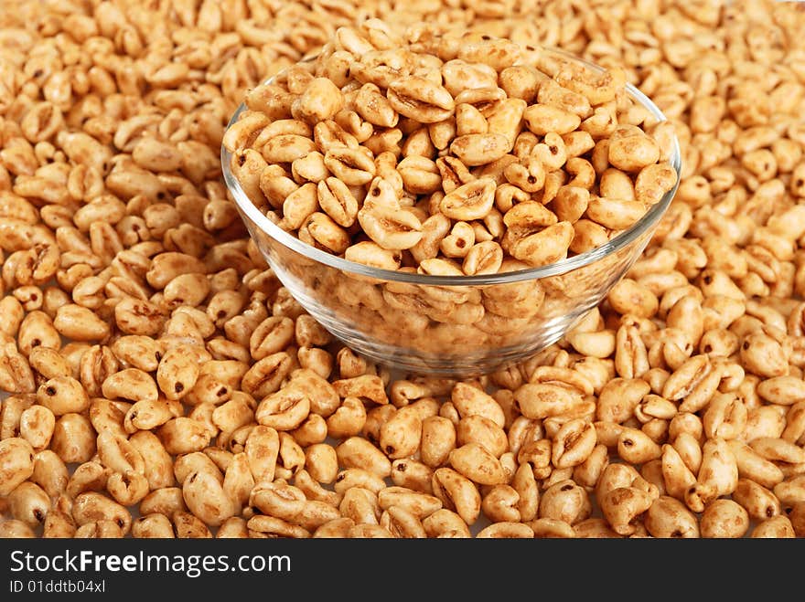 Background with popped wheat grains in cup