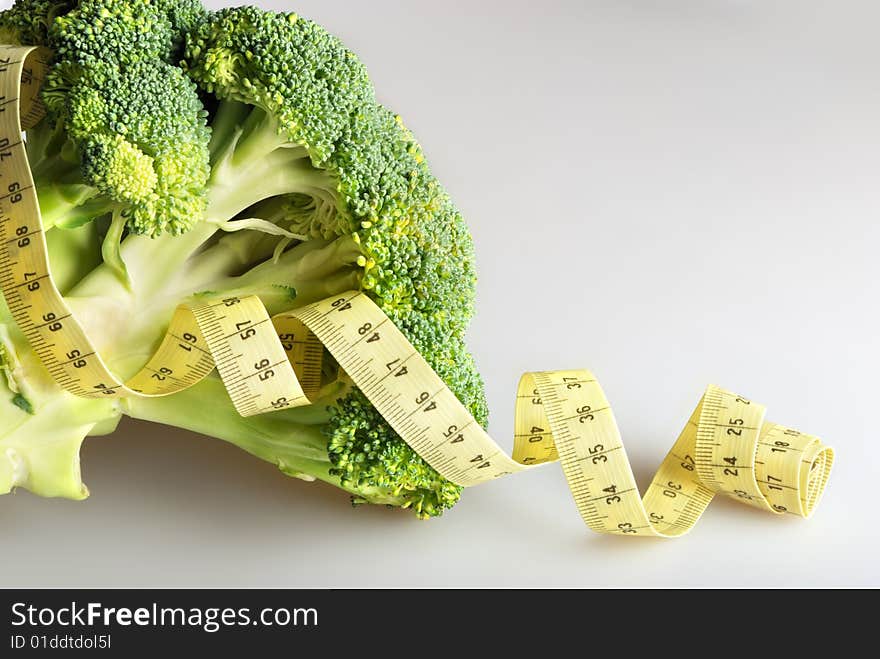 Green broccoli (part of inflorescence) with tape measure. Green broccoli (part of inflorescence) with tape measure