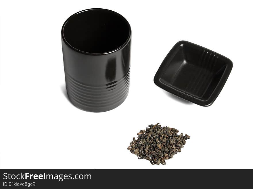 Black cup and green tea leaves