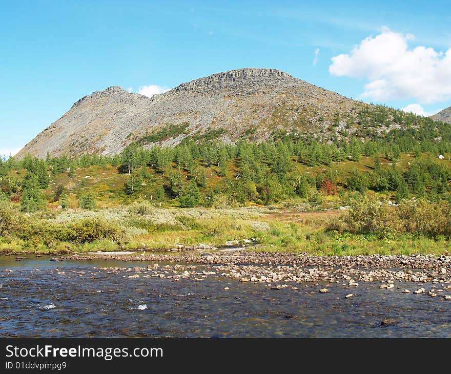 Mountain, forest and river against a backdrop of blue sky. Mountain, forest and river against a backdrop of blue sky.