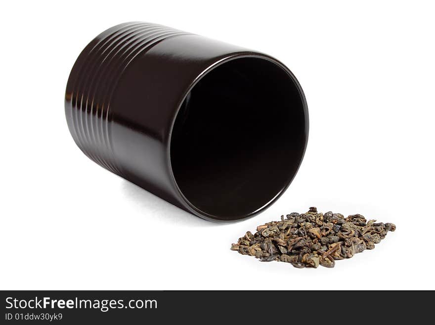 Black cup heap of green tea leaves isolated over white