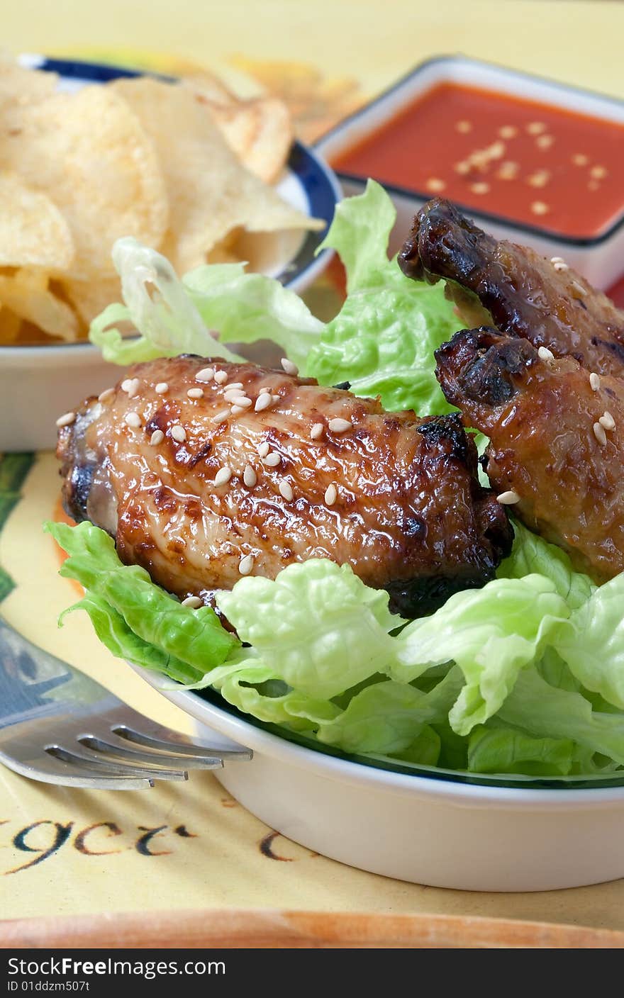 Grilled chicken wings with hot pepper sauce and salad