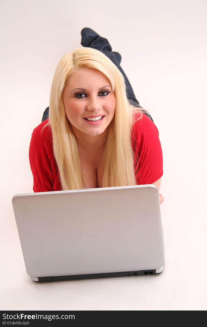 A blond young woman with a laptop. A blond young woman with a laptop