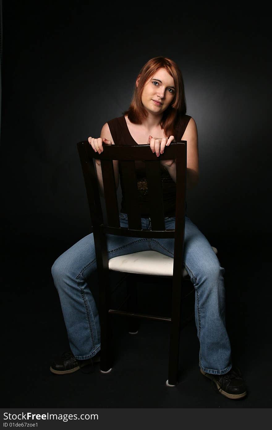 Pretty teenage girl sitting backwards on a chair. Pretty teenage girl sitting backwards on a chair