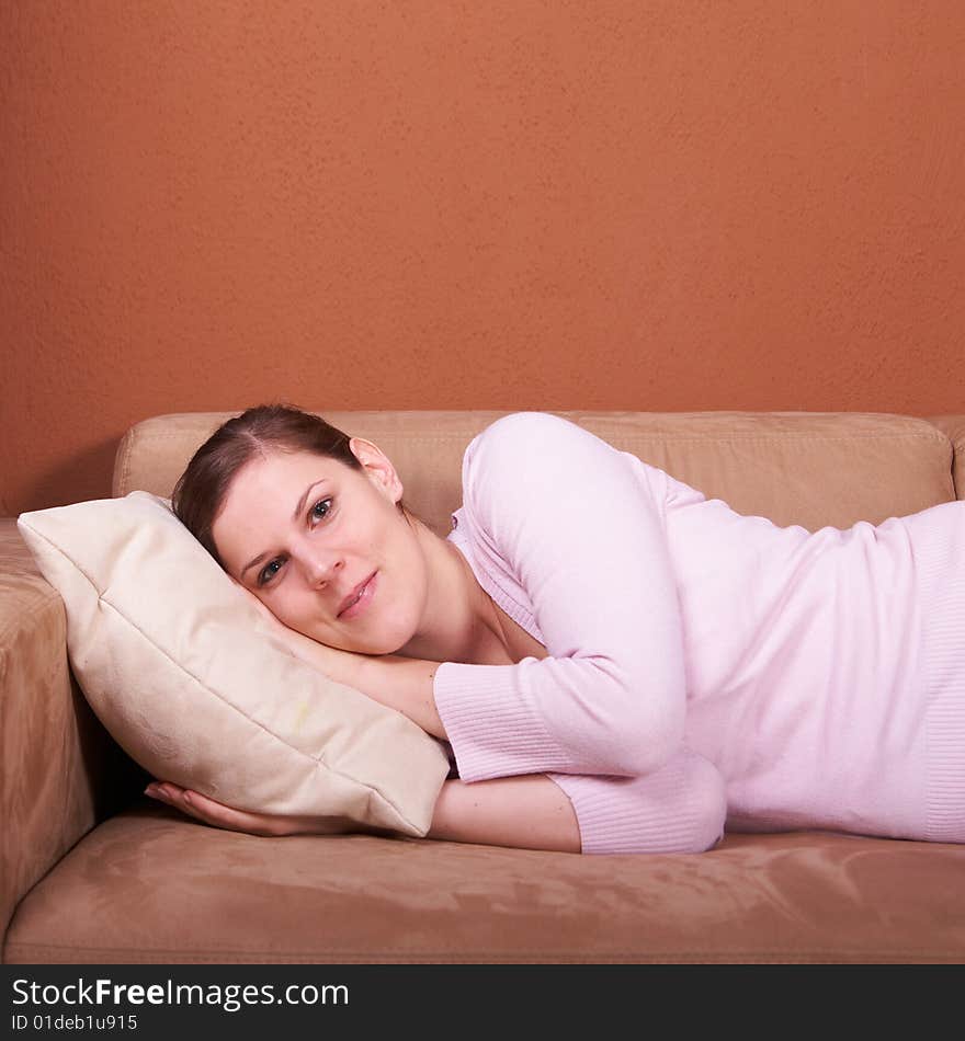 A young woman is lying on a couch and relaxing. A young woman is lying on a couch and relaxing.