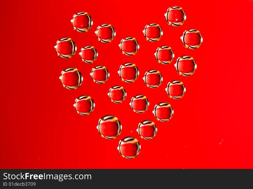 Water drops in the form of heart on a celebratory background