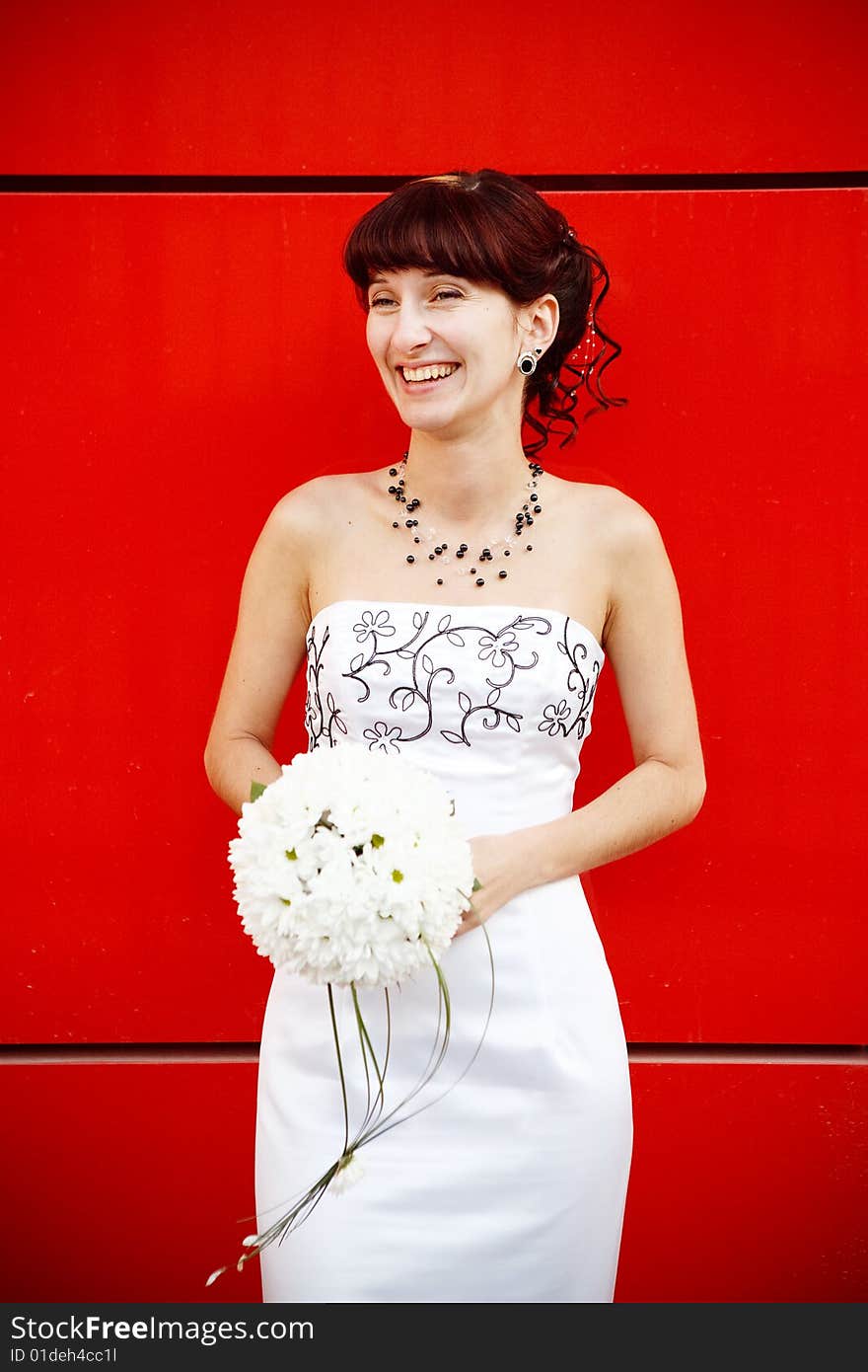 Funny bride by the red wall. Funny bride by the red wall