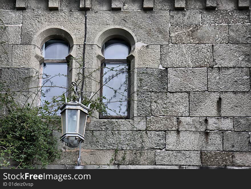 Fragment of old castle wall with windows and lantern