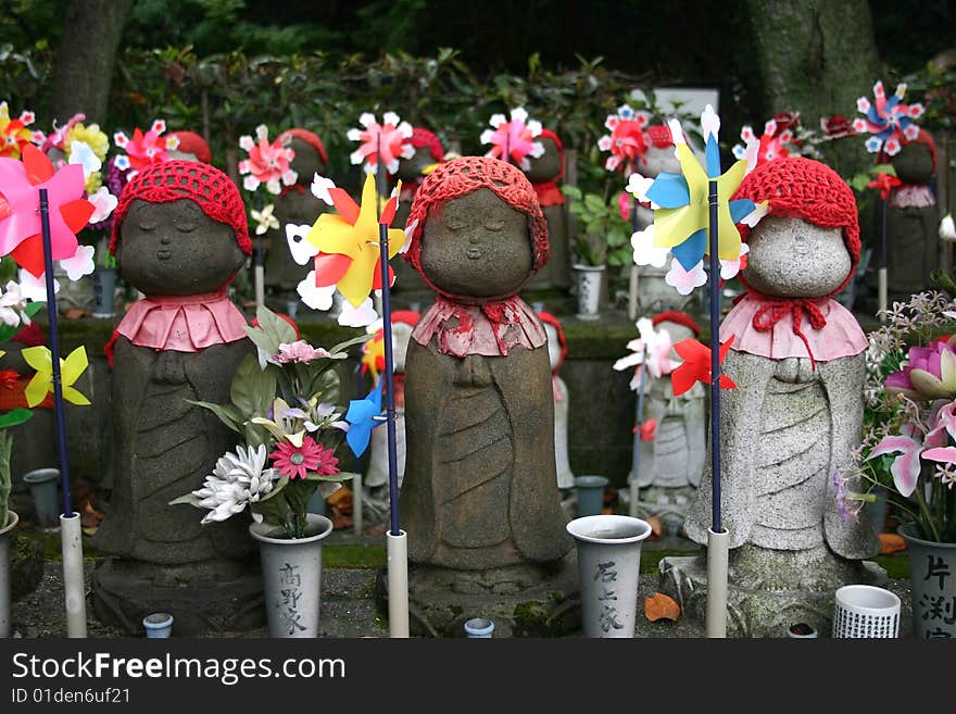 Japanese Doll Statues With Red Hats And Windmills