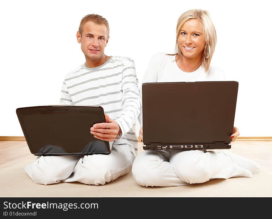 Portrait of a happy couple sitting on the floor with laptop. Portrait of a happy couple sitting on the floor with laptop