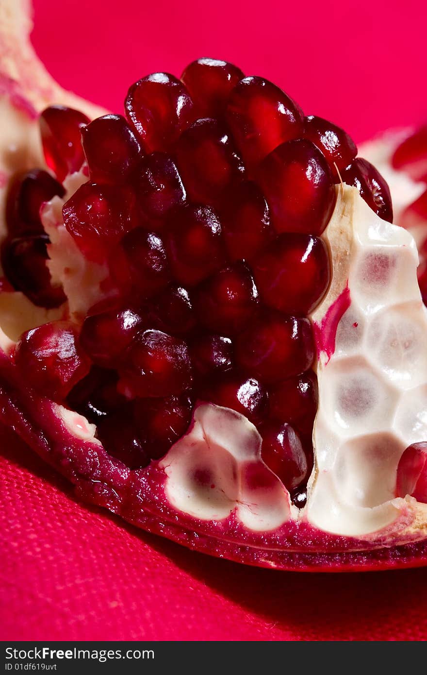 Fruit series: ripe pomegranate on the red background