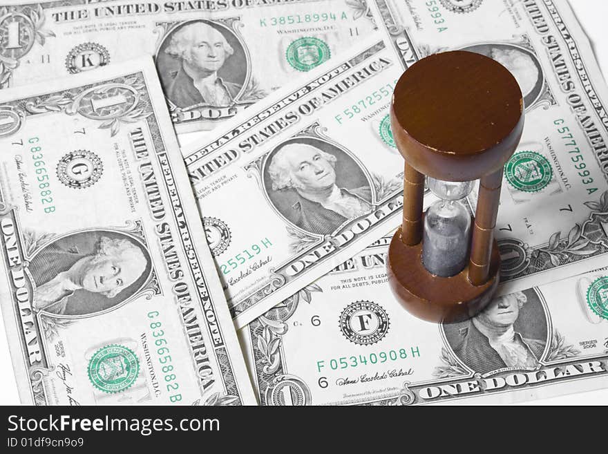 Sand clock with some dollars as a background. Sand clock with some dollars as a background.