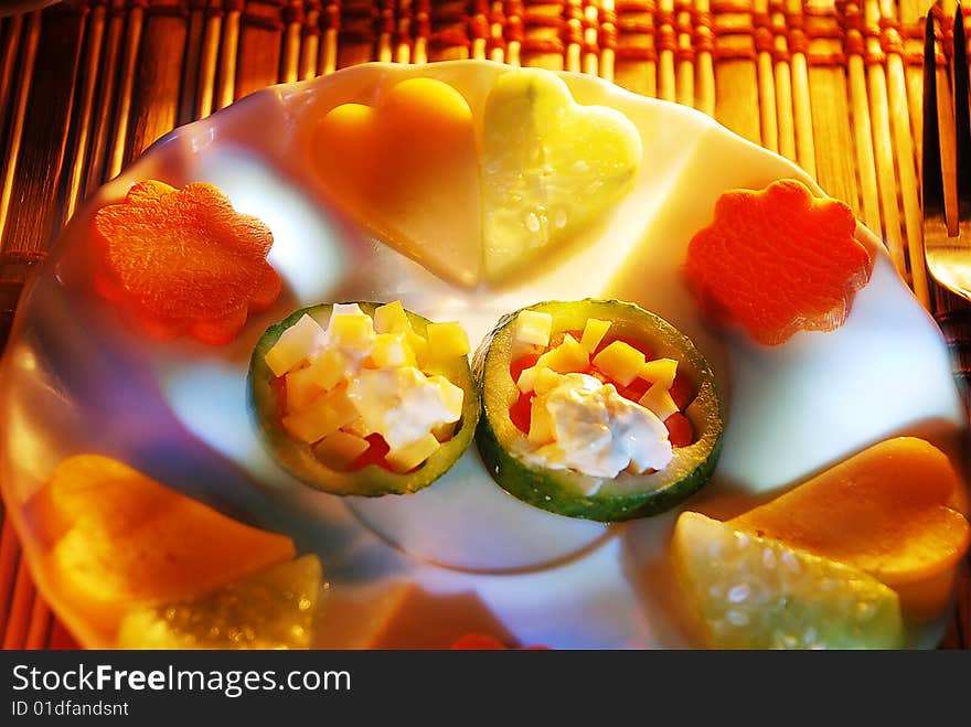 Dish, decorated vegetable hearts and flowers. Vegetarian. Unusual evening illumination. Dish, decorated vegetable hearts and flowers. Vegetarian. Unusual evening illumination.