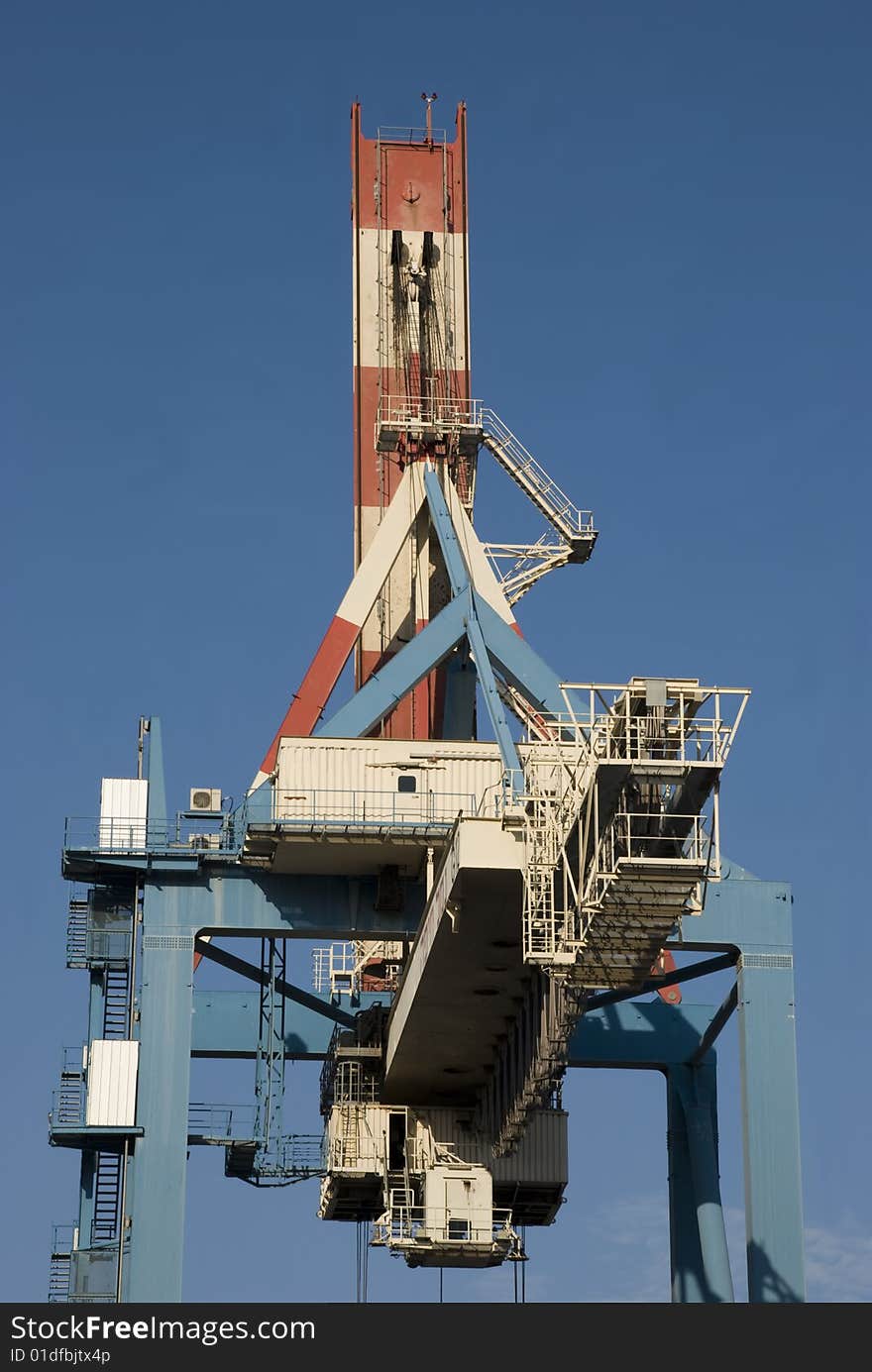 Heavy industrial crane used to load and unload large cargo ships at a port. Heavy industrial crane used to load and unload large cargo ships at a port