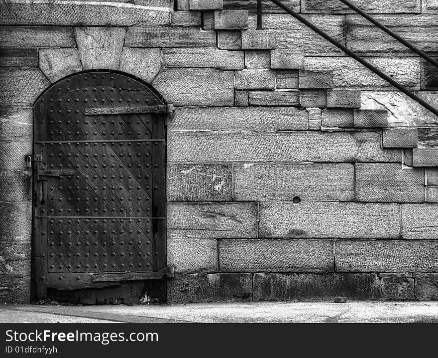 Historical fortress door and steps in black and white.