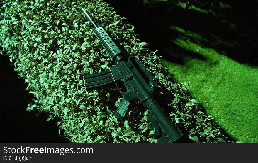 Plastic Machine Gun on green fence