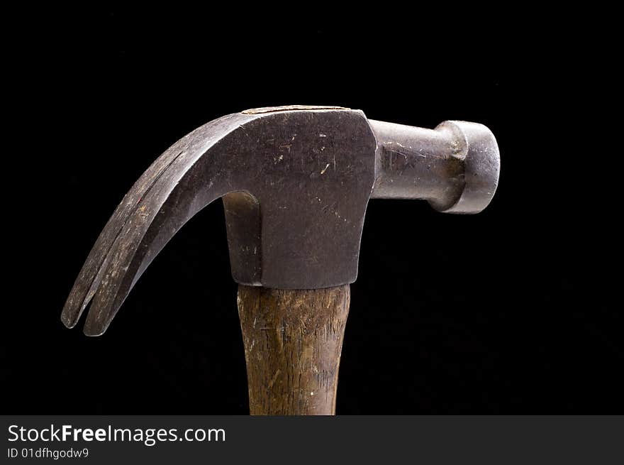 Old wood handled hammer against a black background