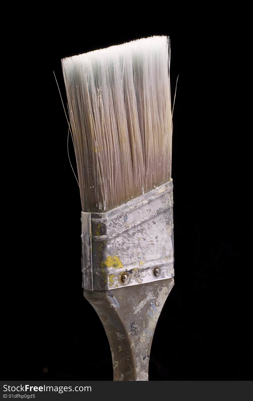 Old wood handled paintbrush on a black background