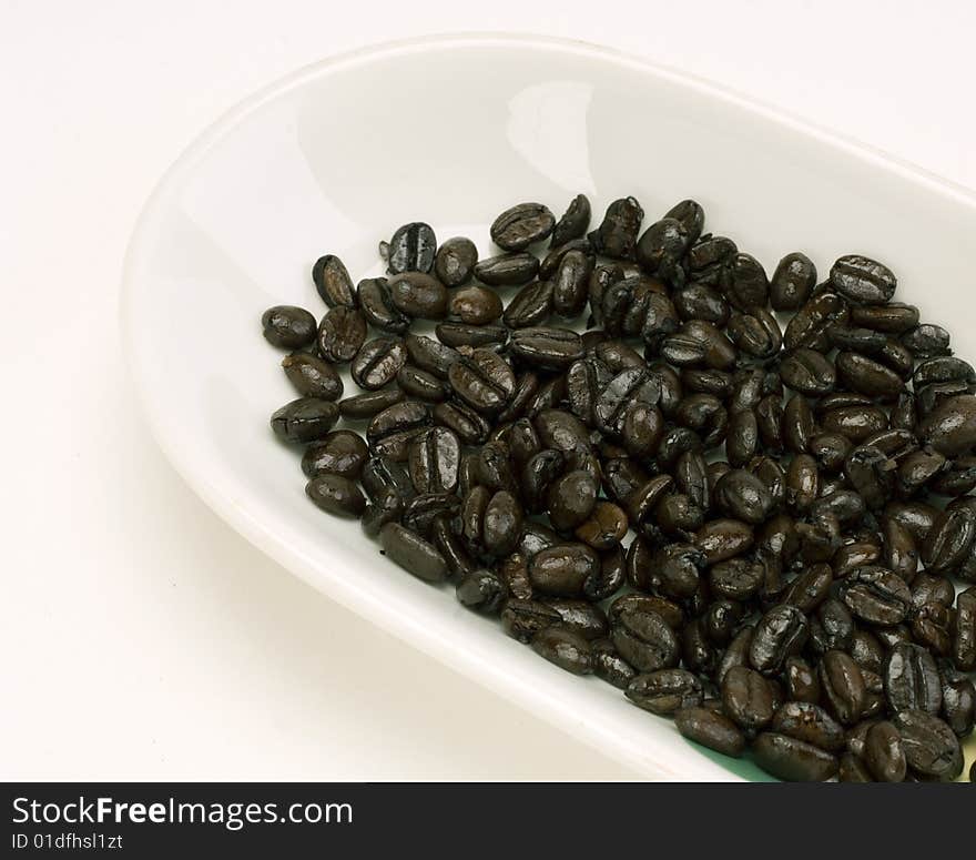 Fresh Arabica coffee beans in a white dish