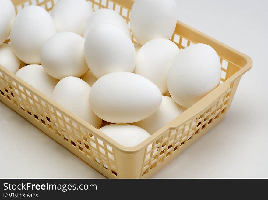 Fresh eggs in a basket on a white background