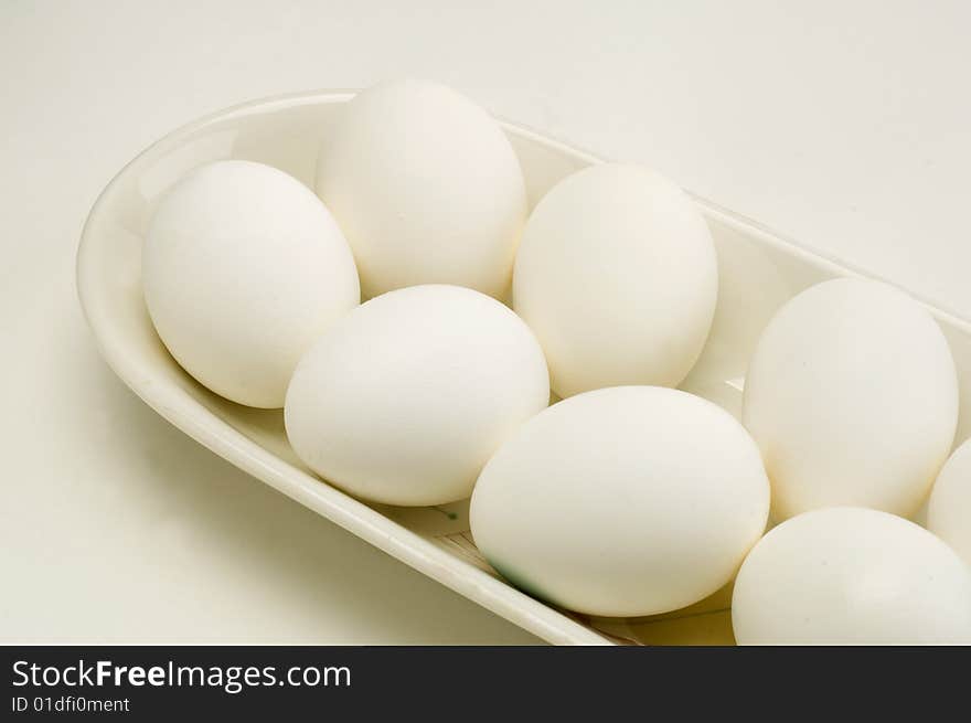 Fresh eggs in a white dish on a white background