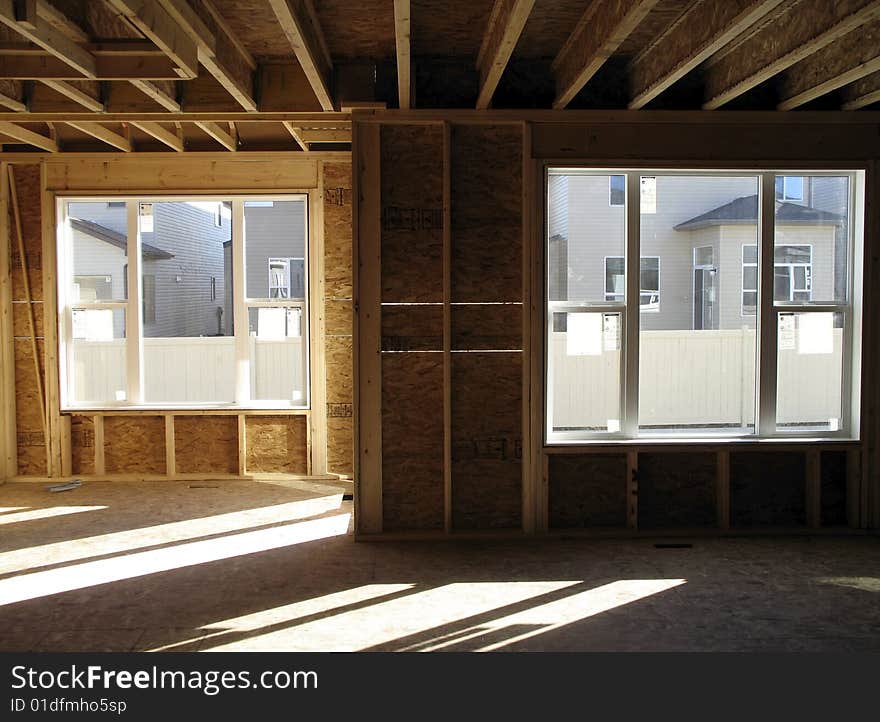 Inside a framed house, sun shining through windows