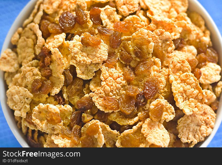 Bowl of cereal with raisins, milk and orange juice