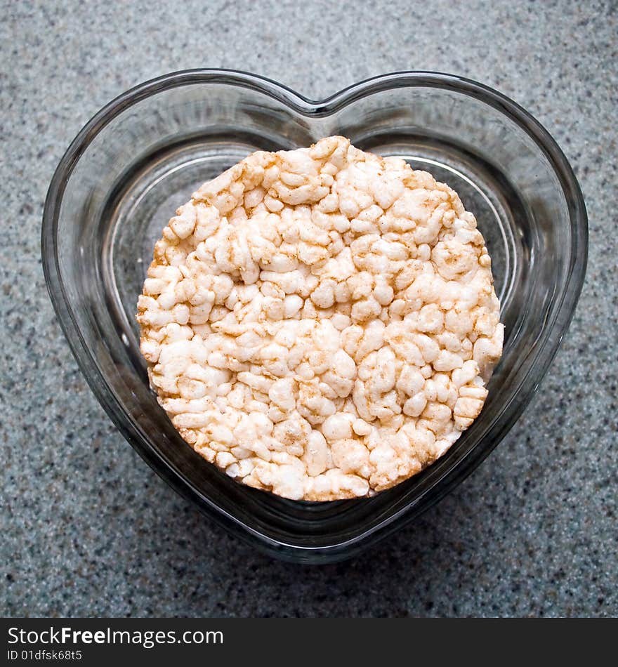 Rice cakes in a clear heart shaped dish on a kitchen counter. Rice cakes in a clear heart shaped dish on a kitchen counter.