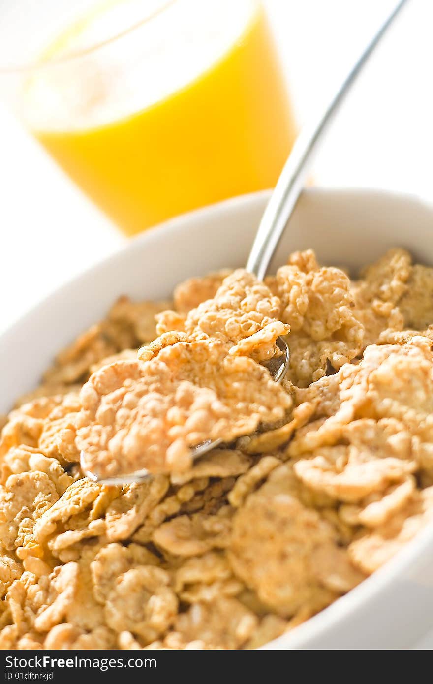 Bowl of cereal with raisins, milk and orange juice