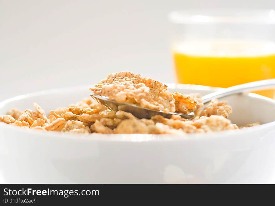 Bowl of cereal with raisins, milk and orange juice