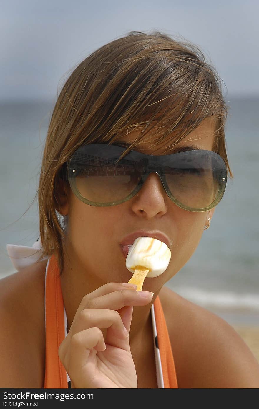 Beautiful girl eating icecream in the beach. Beautiful girl eating icecream in the beach