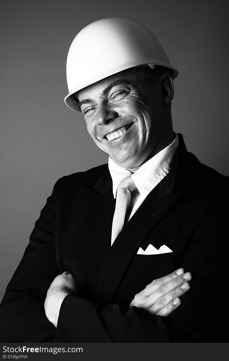 A black and white photograph of a happy man in workers helmet. A black and white photograph of a happy man in workers helmet