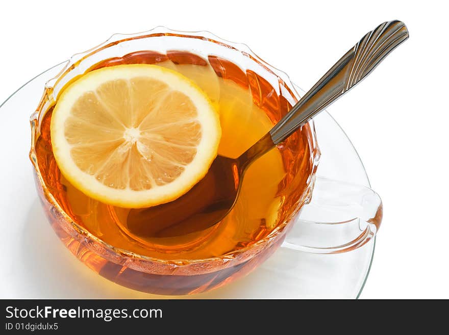 Glass cup with tea and a lemon on a white background