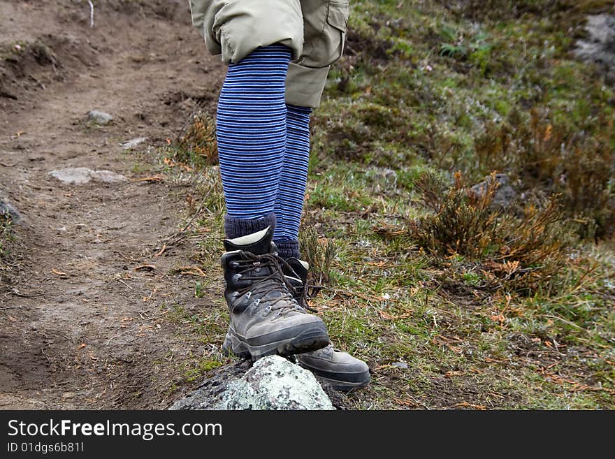 A hikers legs and boots with funny socks. A hikers legs and boots with funny socks