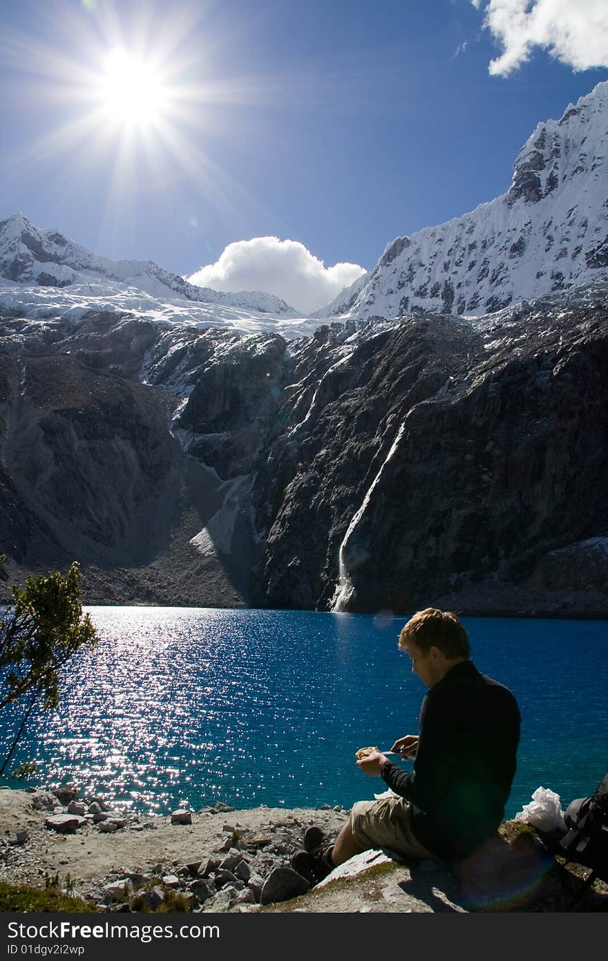 Young man resting at a blue lake. Young man resting at a blue lake